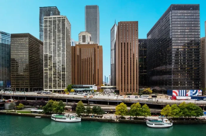 Exterior view of the Hyatt Regency Chicago surrounded by other buildings in Chicago on the waterfront.