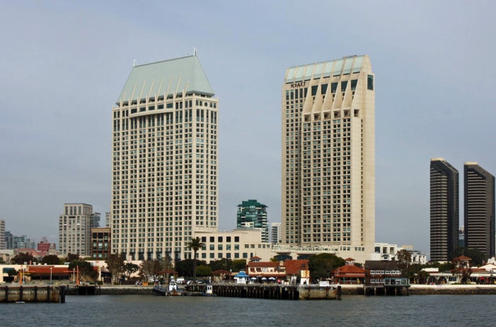 Manchester Grand Hyatt San Diego hotel sitting on the coastline with two tall, wide towers.